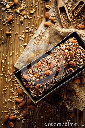 Homemade buckwheat bread with the addition of nuts and seeds in a baking tin on a wooden table, top view. Stock Photo