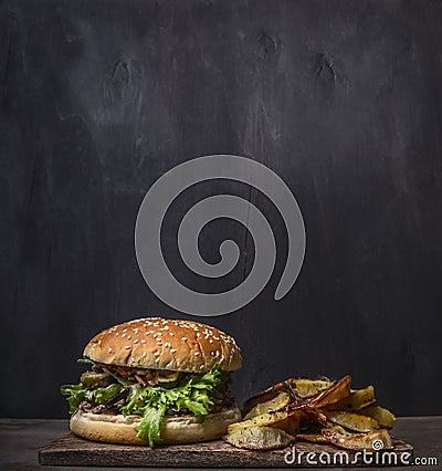 Homemade burger with tuna and fried potatoes with dill and garlic on a cutting board wooden rustic background border, place for Stock Photo