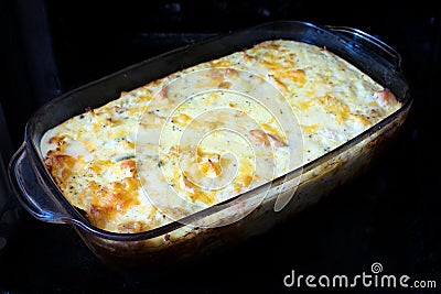 Homemade casserole with meat, vegetables and cheese in the oven. Stock Photo