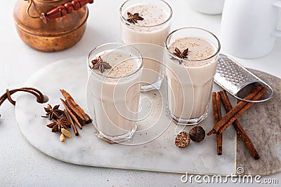 Homemade chai in tall glasses with spices on a board Stock Photo
