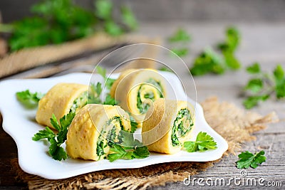 Homemade cheese and herbs stuffed omelet on a plate and vintage wooden table. Cut omelet Stock Photo