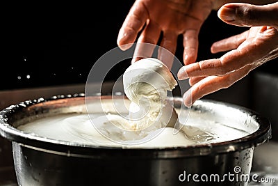 The homemade cheese maker produces handmade mozzarella with fresh bio milk. process of making mozzarella. Italian hard cheese Stock Photo