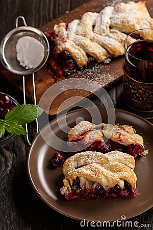 Homemade cherry puff pastry braid, on blue wooden background. Stock Photo