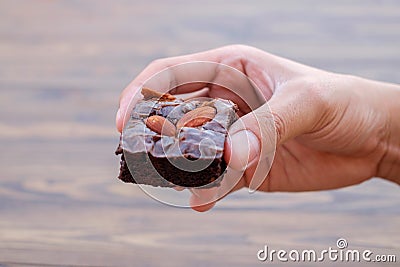 Homemade chocolate brownie with almond in right hand Stock Photo