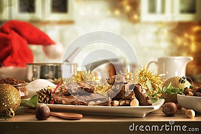 Homemade chocolate with hazelnuts on wooden bench in christmas kitchen Stock Photo