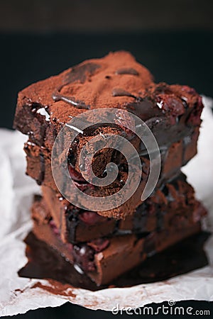 Homemade chocolate sweet brownies cakes with cherry and chocolate sauce or syrup on a dark background, horizontal Stock Photo