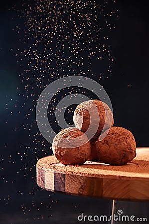 Homemade Chocolate Truffles with Sifting Cocoa on Wooden Board on Dark Background. Copy Space For Your Text Stock Photo