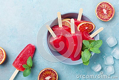 Homemade citrus ice cream or popsicles decorated mint leaves and orange slices. Frozen fruit juice. Stock Photo