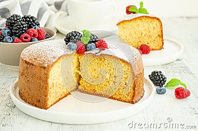 Homemade classic vanilla sponge cake or biscuit sprinkled with powdered sugar and fresh berries Stock Photo