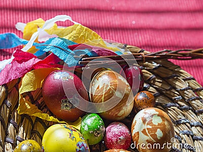 Homemade Colorful Painted easter eggs in straw flat basket with easter stickers and Pomlazka - czech traditional braided Stock Photo