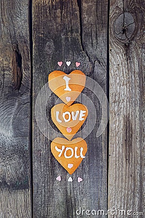 Homemade cookies in the form of heart with letteing I Love You and sweets sugar candy hearts on the rustic wooden background. Vale Stock Photo