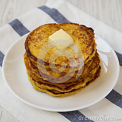 Homemade corn meal Johnny cakes with butter on a white plate, side view. Closeup Stock Photo