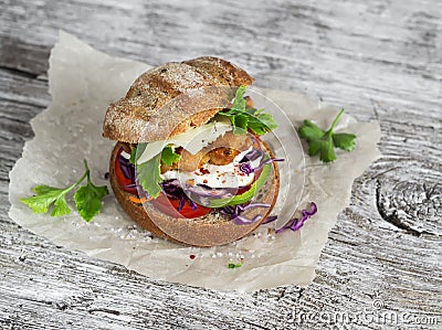 Homemade crispy fish burger on a rustic wooden board Stock Photo