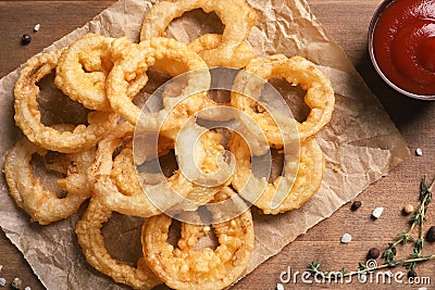 Homemade crunchy fried onion rings and sauce on wooden background Stock Photo