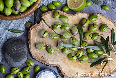 Homemade crushing olive making. Fresh green olives are breaking one by one. Crushing olives with stone. Preparing pickled olives Stock Photo