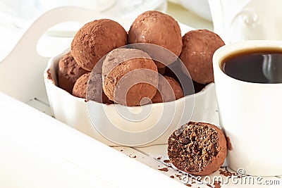 Homemade dark chocolate vegan truffles with nuts plate light background. Selective focus Stock Photo