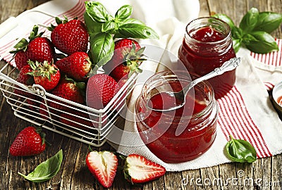 Homemade delicious strawberry jam with basil in a glass jar and Stock Photo