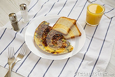 Homemade Denver Omelette on a white plate on cloth, side view Stock Photo