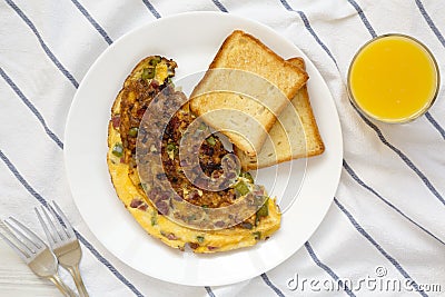 Homemade Denver Omelette on a white plate on cloth, top view. Flat lay, overhead, from above Stock Photo