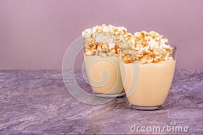 Homemade dessert in glasses. Homemade milk dessert. Vanilla Pudding with Popcorn Stock Photo