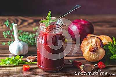 Homemade DIY natural canned hot plum sauce chutney with chilli or tkemali in glass jar Stock Photo