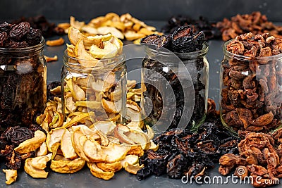 Homemade dried apples, plums, pears and apricots in glass jars, Traditional drying fruits at home, to keep vitamins for cooking Stock Photo