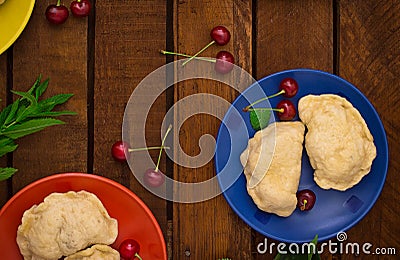 Homemade dumplings with cherries. Wooden background. Top view. Close-up Stock Photo