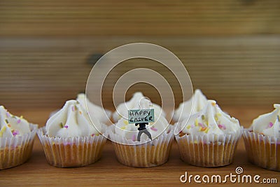 Eastertime cupcakes with a miniature person figurine holding a sign for happy Easter Stock Photo