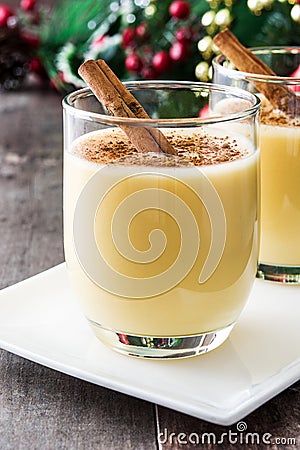 Homemade eggnog with cinnamon on wood. Typical Christmas dessert. Stock Photo