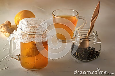 Homemade fermented drink Kombucha in glass jars with lemon on a wooden table. Stock Photo