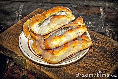 Homemade fish pies on a wooden textured surface against a background of stove brickwork Stock Photo