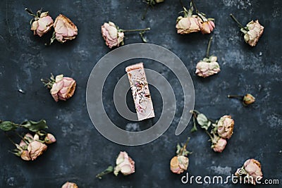 Homemade floral soap. Natural soap and flowers on dark background. Spa concept, natural cosmetics. Flat lay, top view Stock Photo