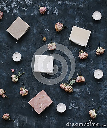 Homemade floral soap. Natural soap and flowers on dark background. Spa concept, natural cosmetics. Flat lay, top view Stock Photo