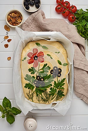 Homemade flower focaccia. Raw focaccia creatively decorated with vegetables on parchment paper. Sourdough dough Stock Photo