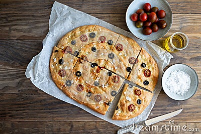 Homemade focaccia with black olives, cherry tomatoes, rosemary and salt Stock Photo