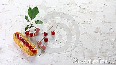 Homemade french eclairs with white icing and cherry jam, fresh cherries. Summer fruit dessert. Top view. Free copy space Stock Photo