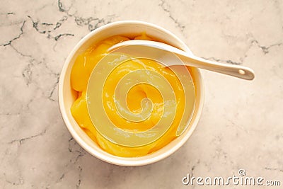 Homemade fresh pudding or tangy lemon curd in a white bowl on marble background.Top view Stock Photo