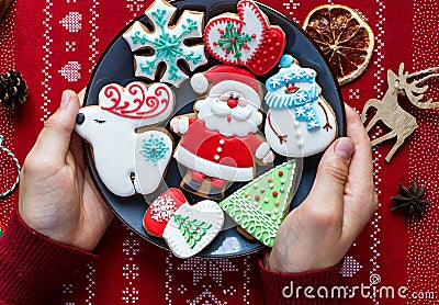 Homemade gingerbreads on plate on wooden background. Holidays and celebration concept, greeting card mockup, festive decoration Stock Photo