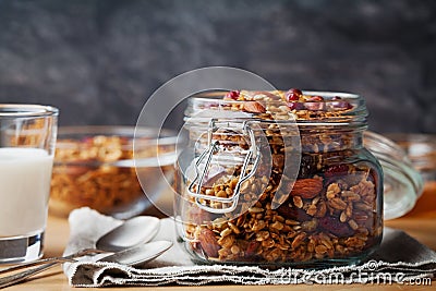 Homemade granola in jar on rustic table, healthy breakfast of oatmeal muesli, nuts, seeds and dried fruit Stock Photo