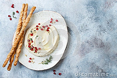 Homemade hummus with pomegranate, thyme, olive oil and pine nuts with grissini bread sticks. Middle Eastern traditional cuisine Stock Photo