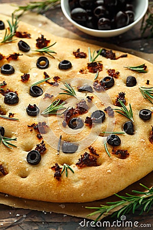 Homemade Italian focaccia with sun dried tomatoes, black olives and rosemary Stock Photo