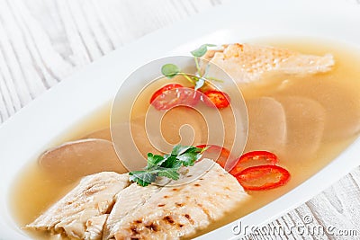 Homemade jelly chicken decorated with greens and eggs on plate on wooden background close up. Stock Photo