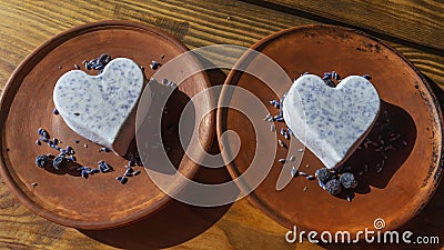 Homemade lavender ice cream in in the shape of a heart in rural clay plate decoration blueberry. Creamy vegan lavender ice cream Stock Photo