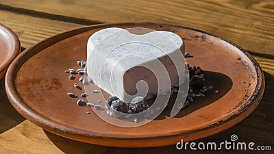 Homemade lavender ice cream in in the shape of a heart in rural clay plate decoration blueberry. Creamy vegan lavender ice cream Stock Photo