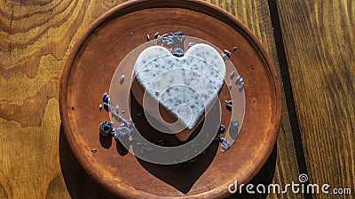 Homemade lavender ice cream in in the shape of a heart in rural clay plate decoration blueberry. Creamy vegan lavender ice cream Stock Photo