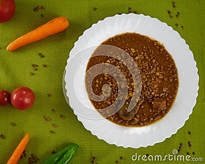 Tasty Homemade Lentil soup with Pork Sausages called Chorizo and Blood sausage called Morcilla in a dish decorated with vegetables Stock Photo