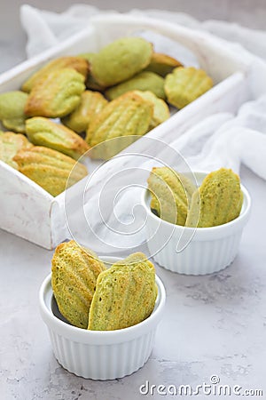 Homemade matcha green tea madeleines on the table and in wooden tray Stock Photo