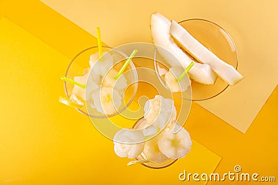 Homemade melon orange fruit sorbet granita popsicles lollies and slices of fresh ripe melon fruit over on yellow background. Top Stock Photo