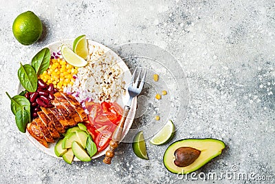 Homemade Mexican chicken burrito bowl with rice, beans, corn, tomato, avocado, spinach. Taco salad lunch bowl. Stock Photo