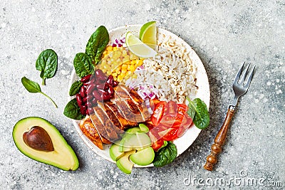 Homemade Mexican chicken burrito bowl with rice, beans, corn, tomato, avocado, spinach. Taco salad lunch bowl. Stock Photo